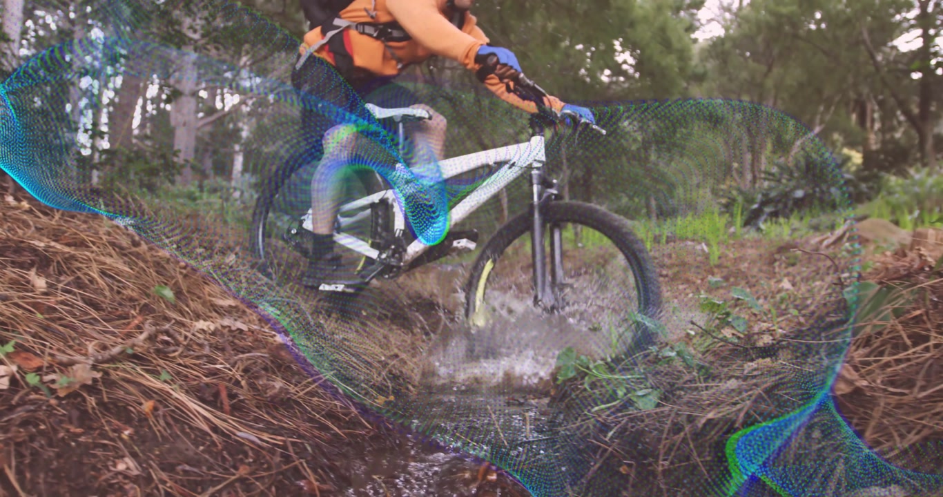 Mountain biker lowering tire into creek showing animated droplets maintaining speed for sports tech