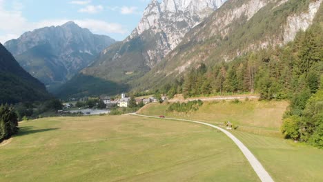 aerial car driving towards picturesque village in julian alps, sunny summer day