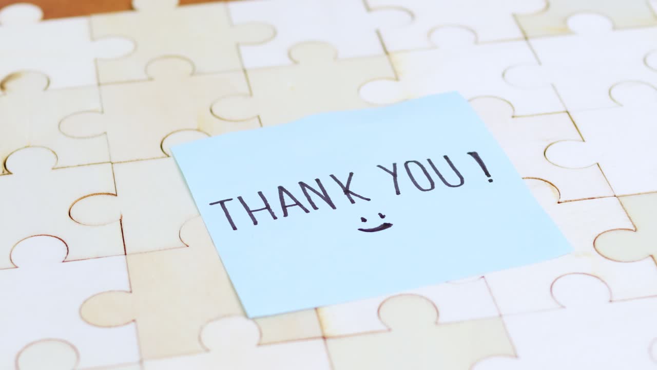 A close-up of a thank you note a puzzle background symbolizing appreciation