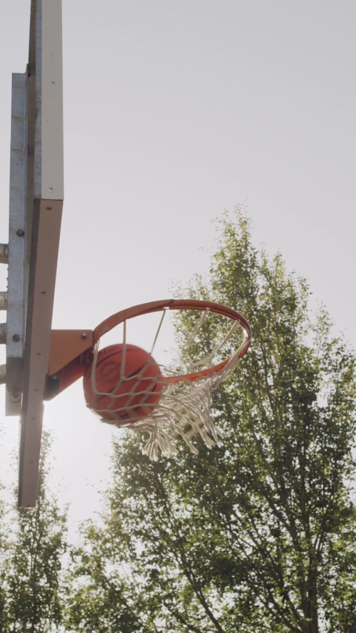 Pallone da basket che segna un canestro all'aperto