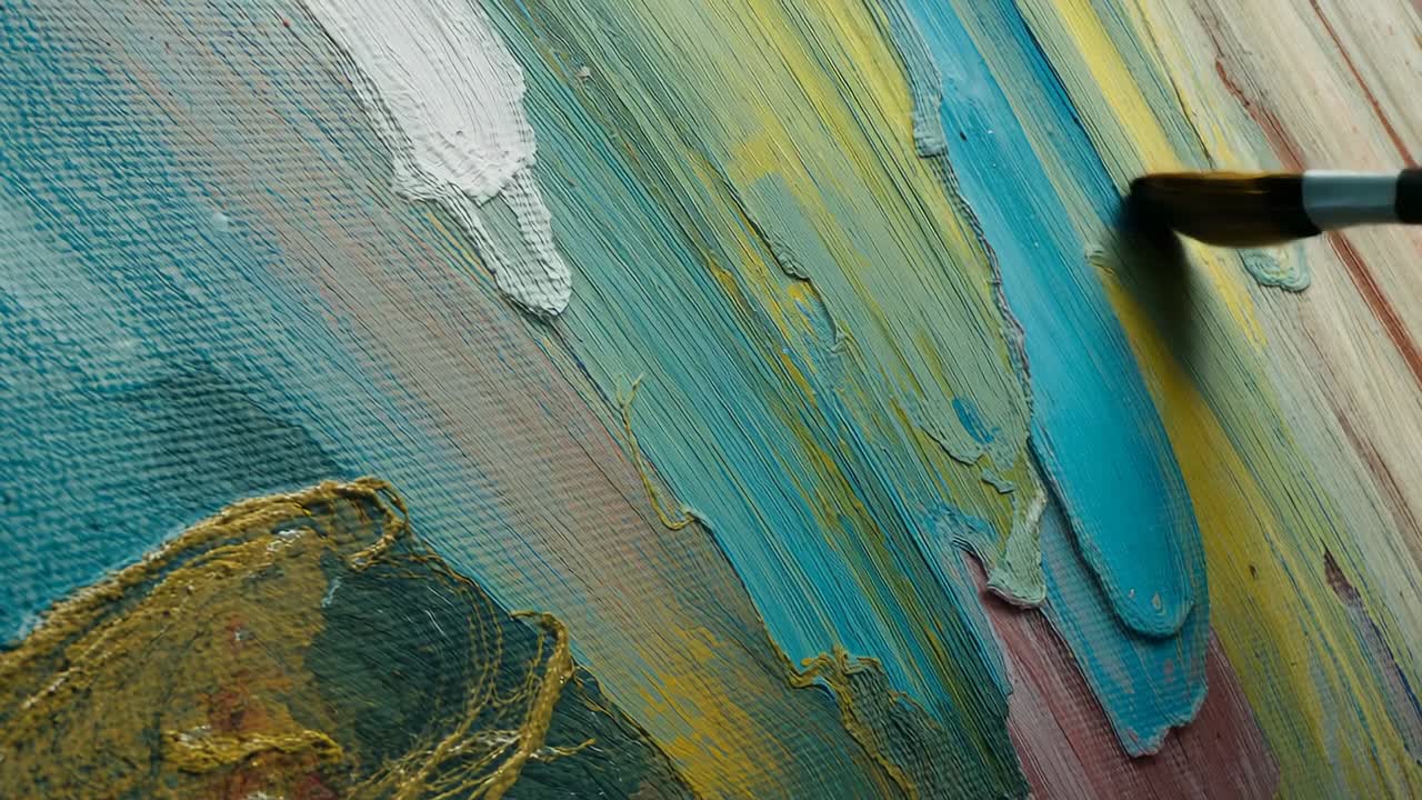 Paintbrush entering and dragging teal paint on studio canvas, unifying colors into vibrant band