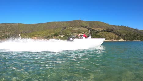 toma de seguimiento cuando la lancha blanca hace un giro cerrado en la laguna del cielo azul
