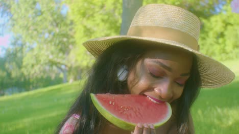 beautiful black woman takes big bite of juicy watermelon slice