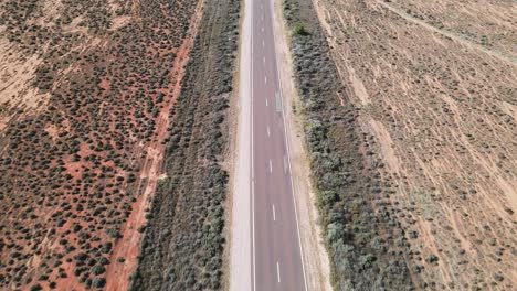 Drohnenantenne-über-Der-Landstraße-In-Der-Wüste-Australiens,-Schwenk-Nach-Oben,-Der-Einen-Windpark-An-Einem-Sommertag-Zeigt