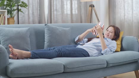 woman relaxing on couch with smartphone