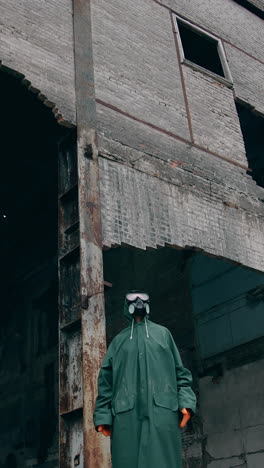 human in destroyed place. ruined buildings in infected zone. person in safety suit and gas mask standing alone in ruined place. vertical video