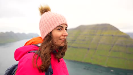 female tourist enjoys the faroe landscape on a windy day