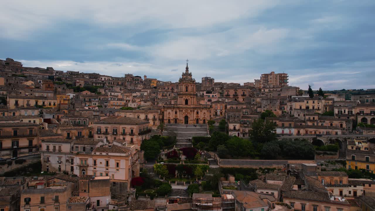 Modica dall'alto, avvicinandosi alla grande scalinata che conduce al Duomo di San Giorgio. Sicilia, Italia, ripresa aerea