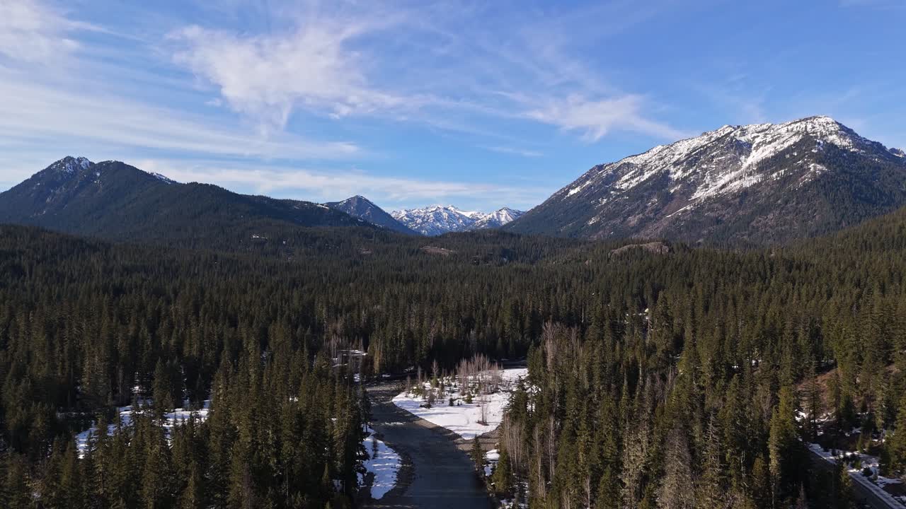retrospectivamente vista panorámica de la cordillera cubierta de nieve con el río por encima del bosque de hoja perenne en cle elum en el estado de washington