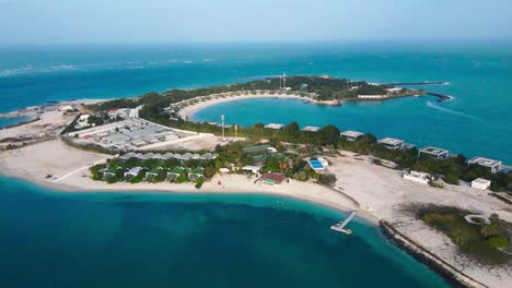 Aerial-view-of-Nurai-Island-displaying-its-gorgeous-sandy-coastline,-sparkling-turquoise-waters,-and-exclusive-retreats