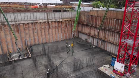 panoramic aerial view of construction workers and engineers laying cement using automatic pump, israel