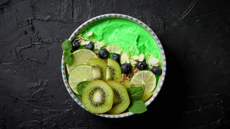 green smoothie or yogurt bowl  with fresh kiwi  blueberries  lime and almond flakes