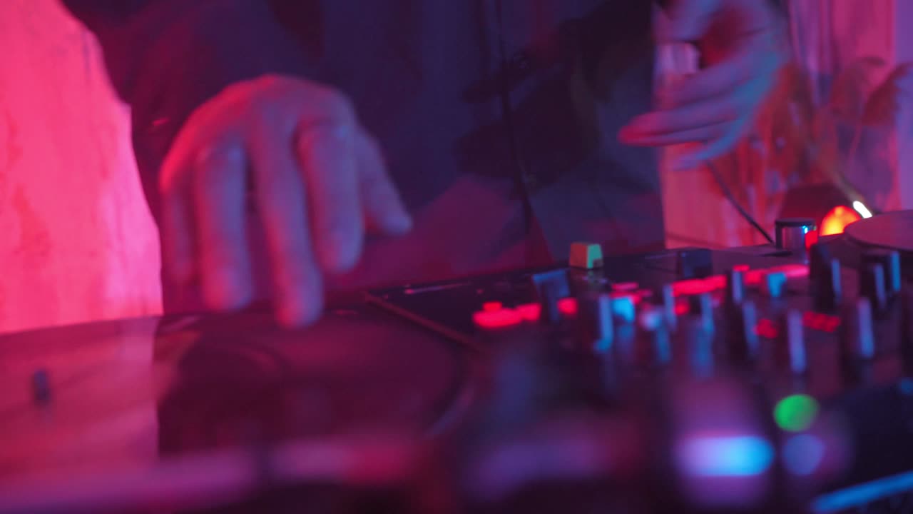 un dj moderno de apariencia asiática realiza una pista de música con iluminación de neón.