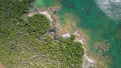 Vista-Aérea-De-La-Costa-Rocosa-Boscosa-Del-Lago-Huron-Con-Agua-Clara