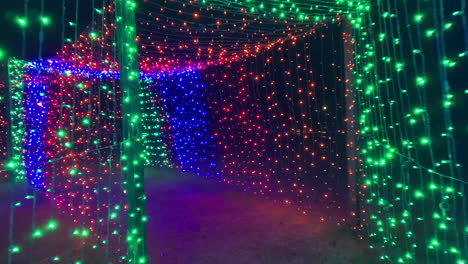 foto nocturna de caminar dentro del túnel de luces navideñas