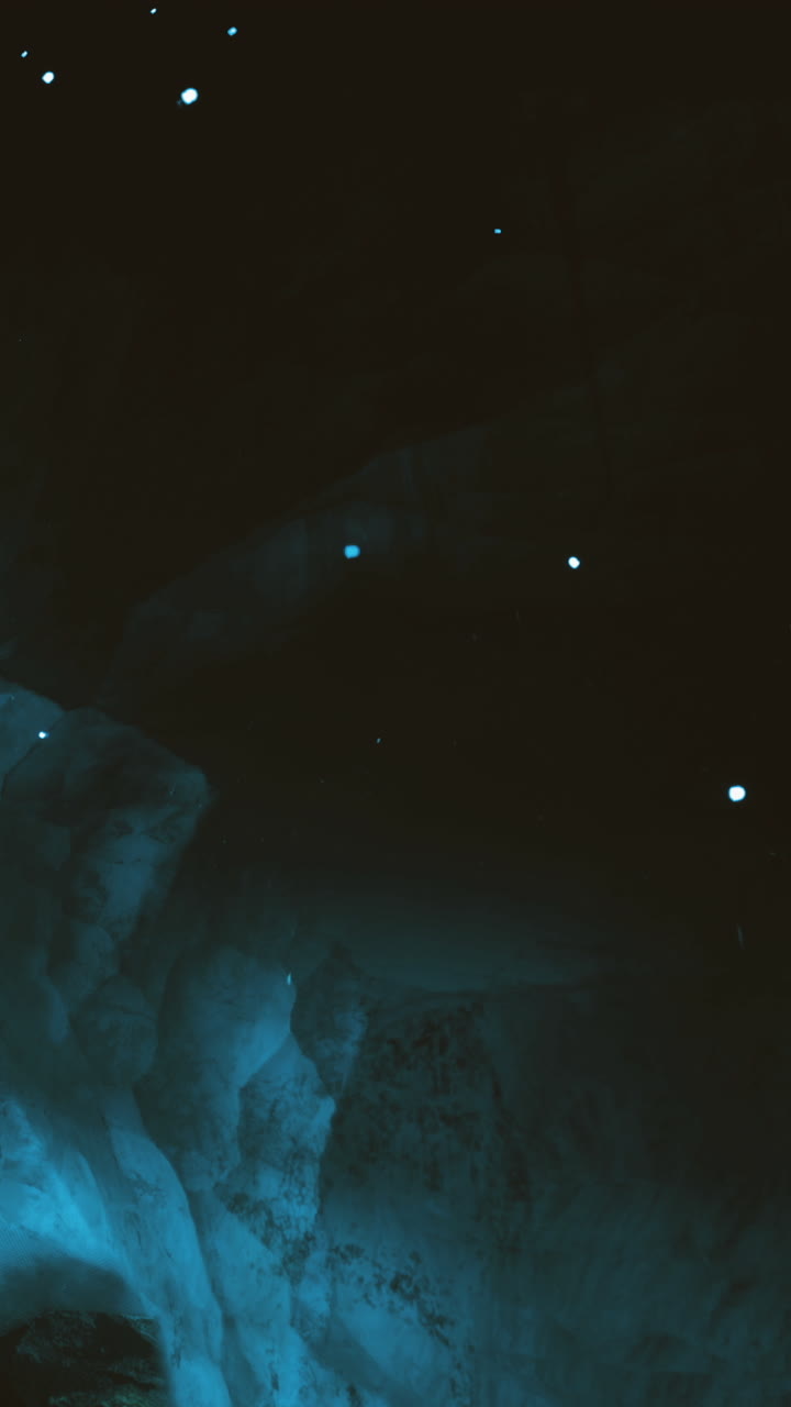 Exploring a dark cave with glowing crystals and a mysterious blue light