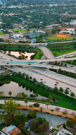 road interchange of highways and freeways in colorful miami. city scenery with lively traffic from top view. vertical video