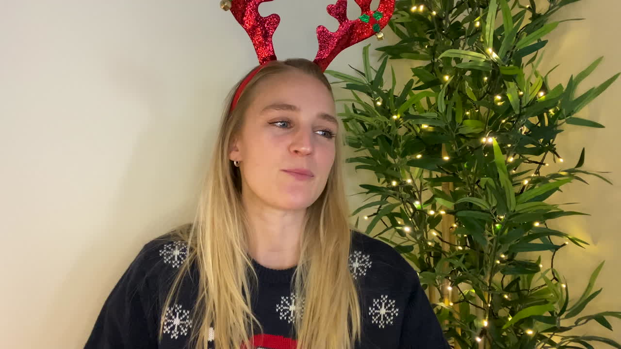 카메라에 직접 말하는 크리스마스 화상 통화 중인 젊은 여성