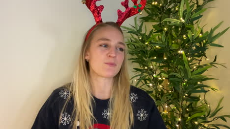 young woman on christmas video call talking directly into camera