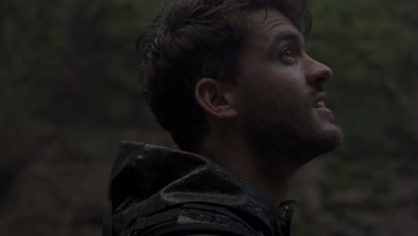 man with a beard, eyes closed, and his face turned upwards, as rain falls on him. the setting is the lush, green environment of catarata del toro, an authentic moment of connection with nature
