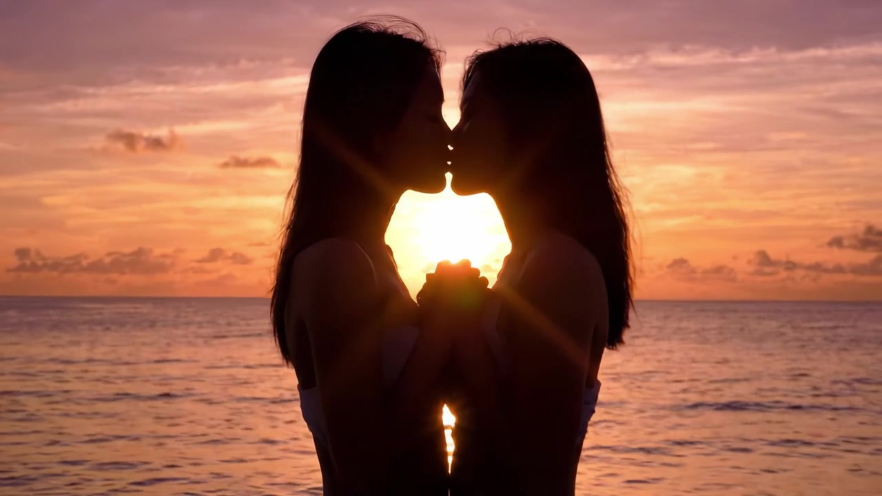 Momenti intimi: Due silhouette al tramonto, che catturano l'essenza dell'amore e della connessione su una spiaggia serena
