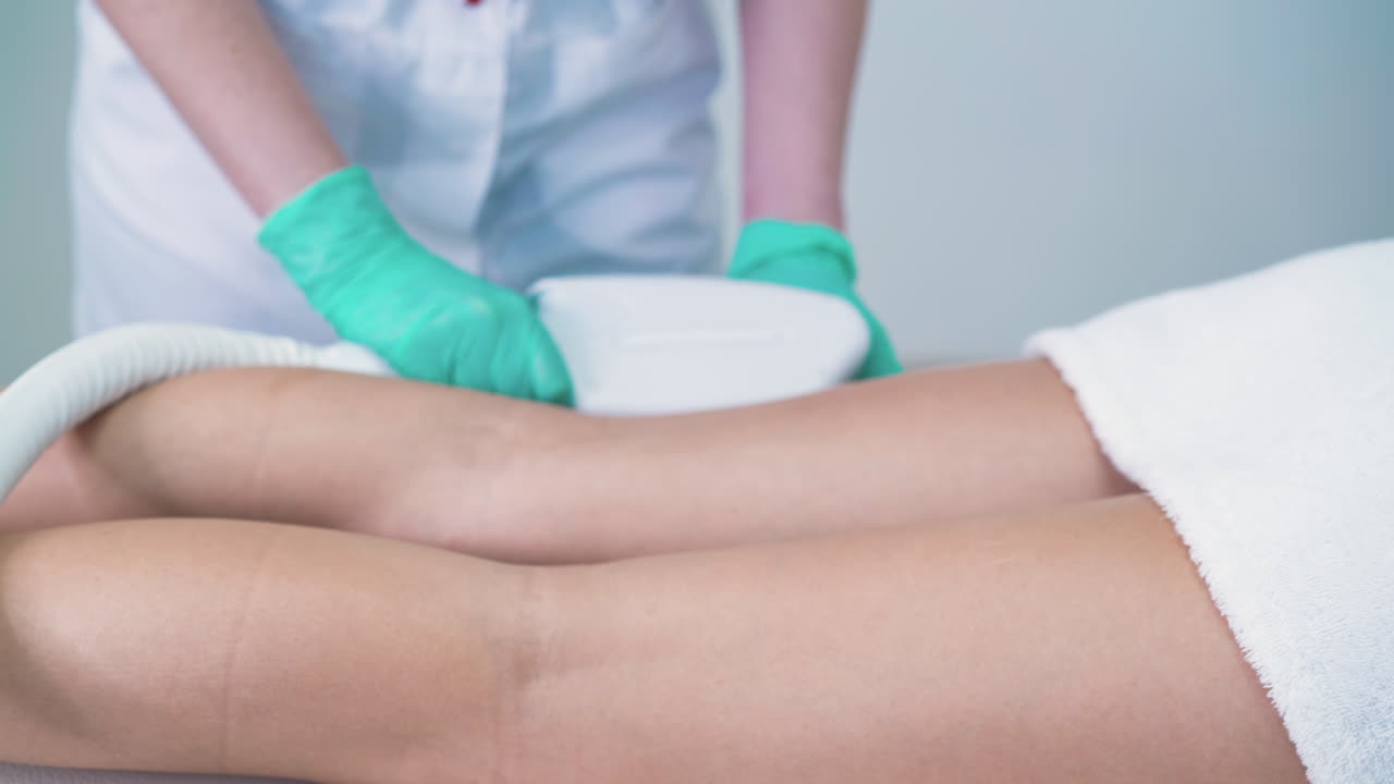 косметолог настраивает халат клиента перед лазерной эпиляцией