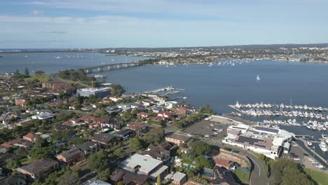 seaside waterfront residential neighborhood roads, car, homes, houses, and properties near marina and highway car bridge over the ocean water