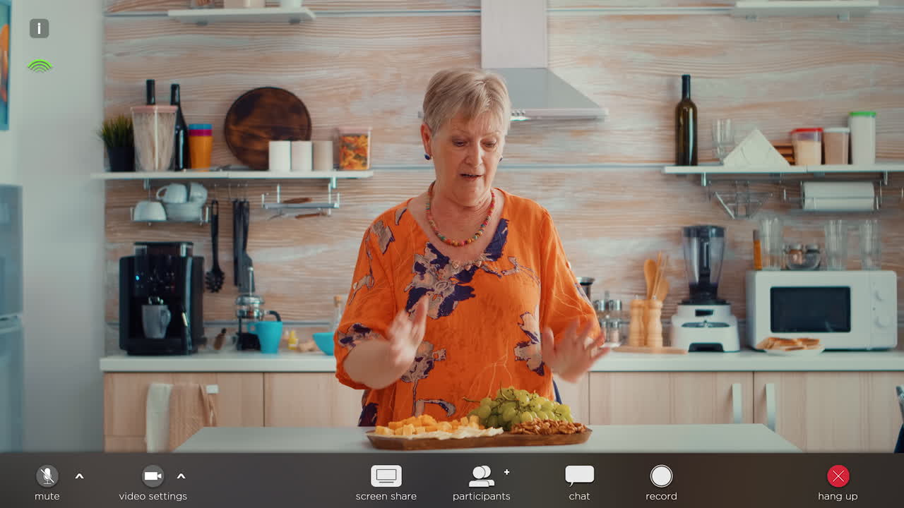mujer anciana haciendo una llamada de video en la cocina