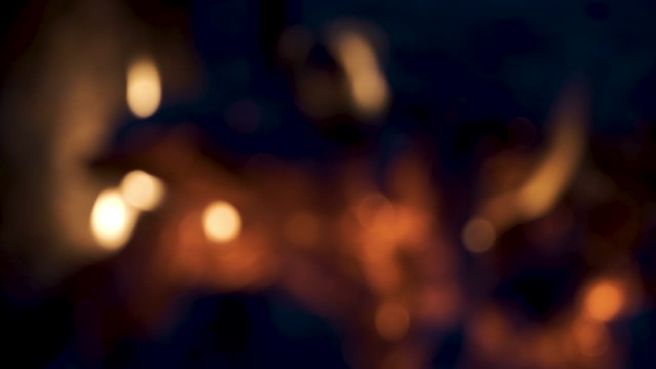 Stufa sfocata con fuoco acceso. Bellissimo bokeh colorato di fiamme da barbecue. Sfondo sfocato con legna che brucia nel camino, primo piano.
