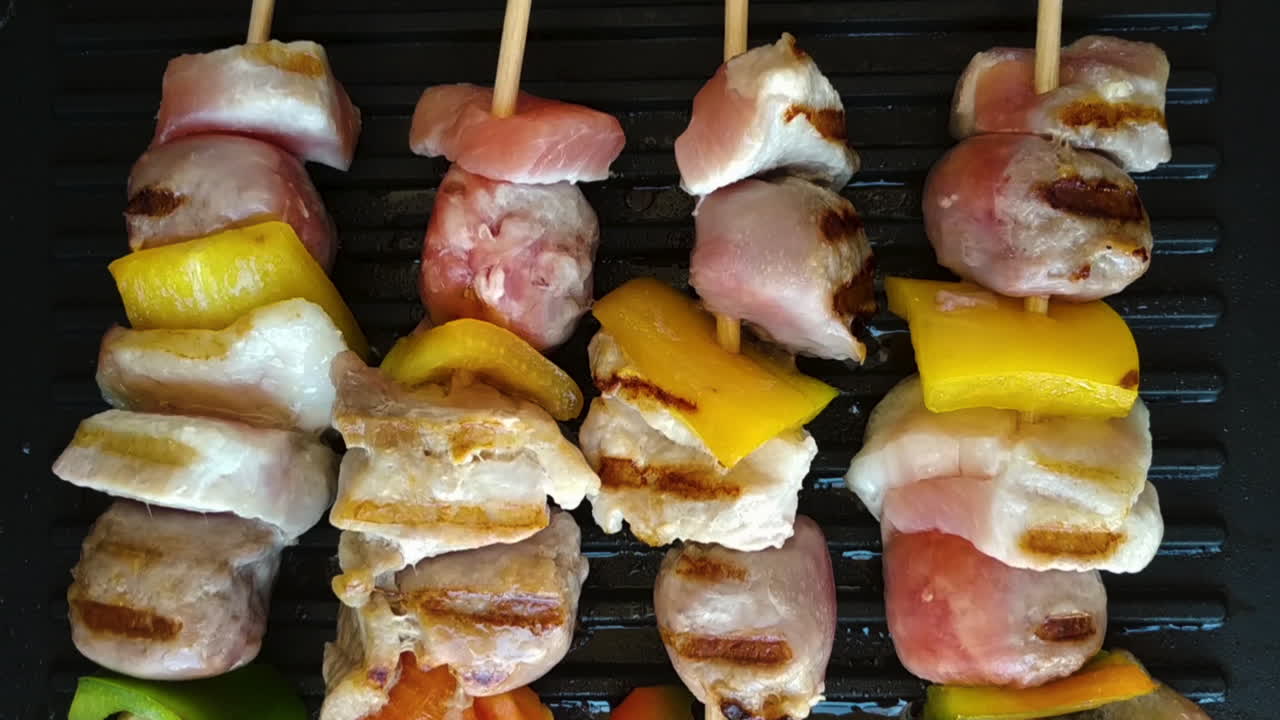 primer plano de cuatro sabrosos pinchos a la parrilla, pollo, salchicha y pimienta, control deslizante