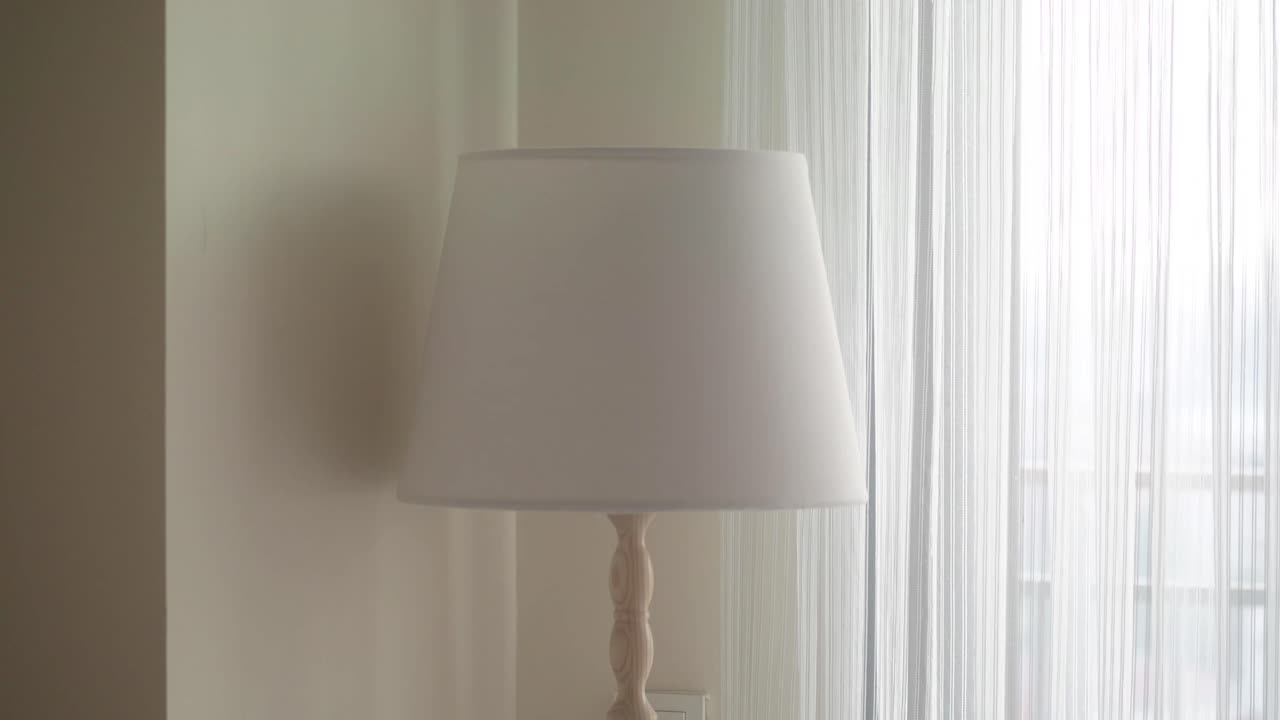 A lamp near a window with curtains