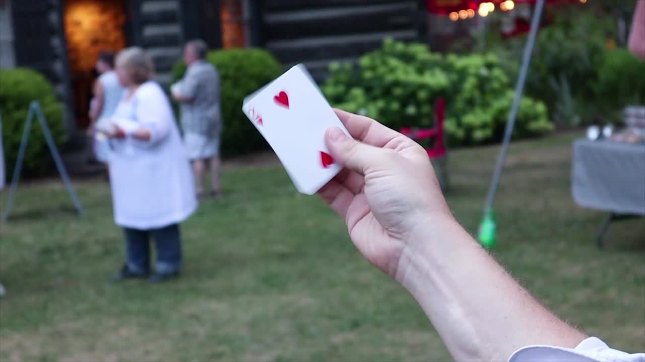 Magician uses sleight of hand to make a card seem to disappear, then reappear.
