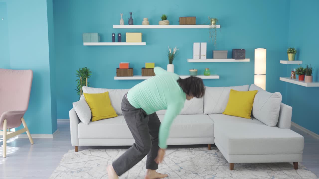 Funny man falls to the ground while practicing martial arts at home.