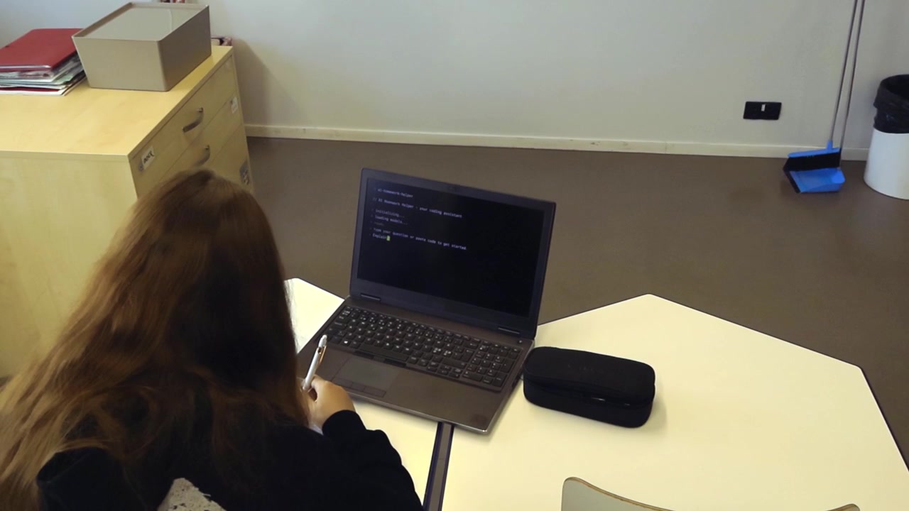 Young female student sitting at her desk in a classroom, learning to code by following instructions from an artificial intelligence program running on her laptop while taking notes