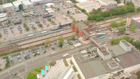 Toma-Aérea-Hacia-La-Estación-De-Tren-De-Stevenage-Junto-A-Un-Enorme-Aparcamiento