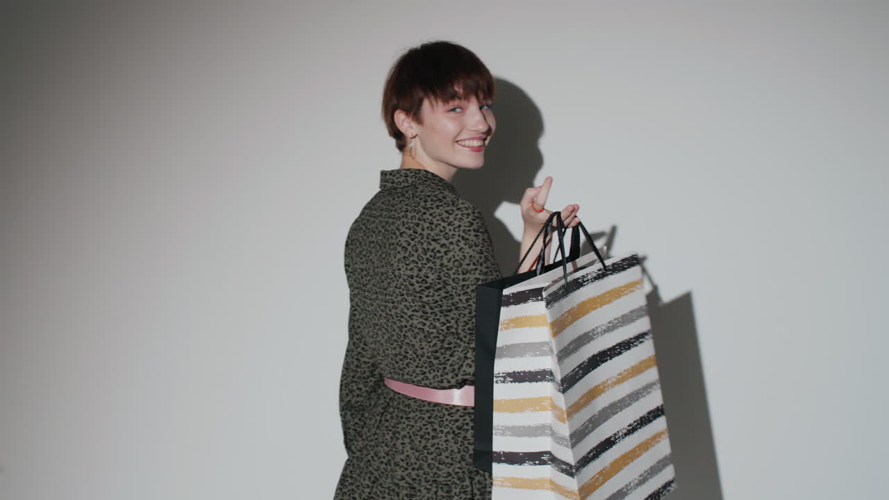 hermosa chica posando con bolsas de compras en el estudio