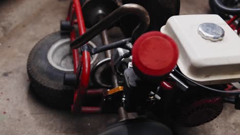 extreme close up shot of mechanic testing his diy go kart in his garage with soot shooting from the exhaust