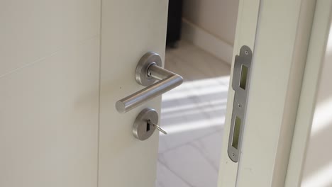 open white door with metal handle and lock