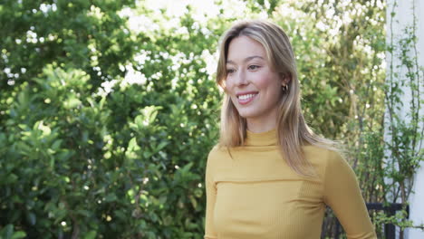 Portrait-of-happy-biracial-woman-with-blonde-hair-in-garden,-slow-motion,-copy-space