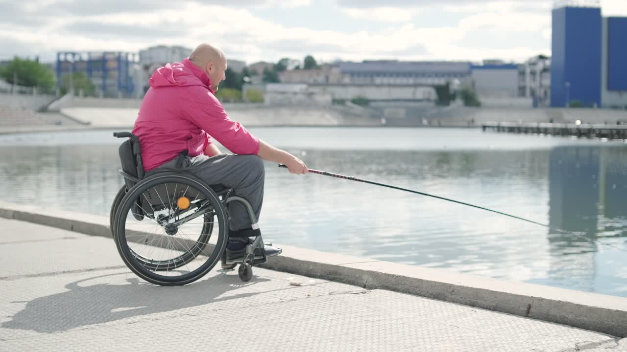 persona con discapacidad física que utiliza silla de ruedas para pescar en el muelle de pesca