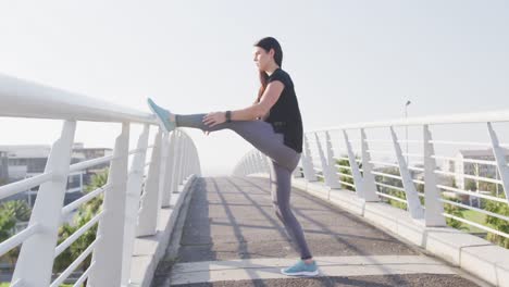 mujer joven estirándose antes de correr
