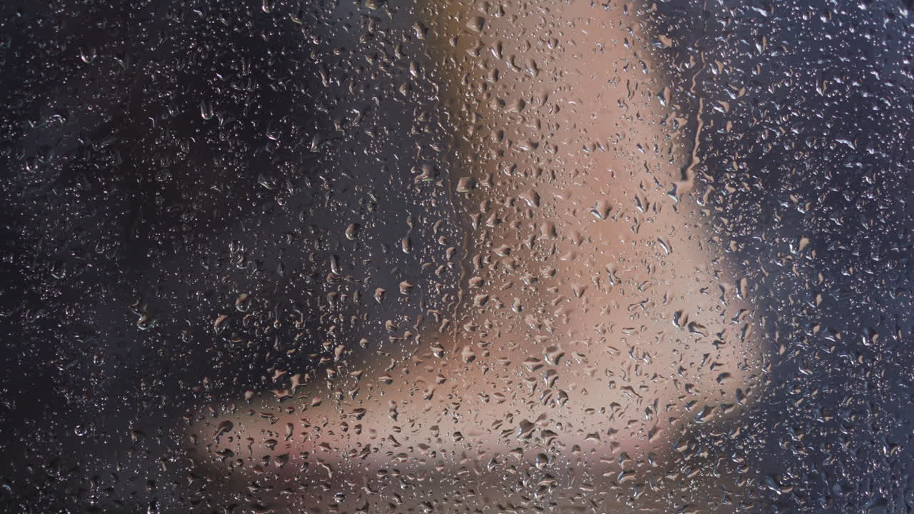 cabina de ducha de vidrio con gotas contra la mujer lavando los pies