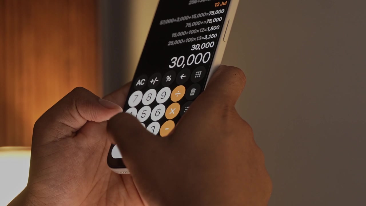 Hand Using Calculator App on Smartphone for Calculation.