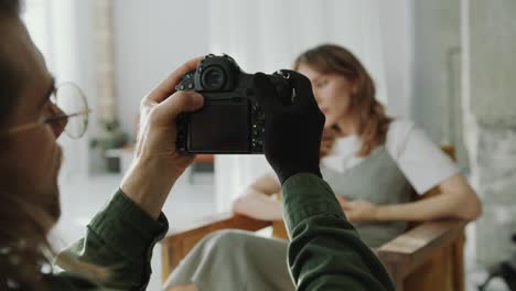 young good-looking woman posing in front of photographer in minimalist room