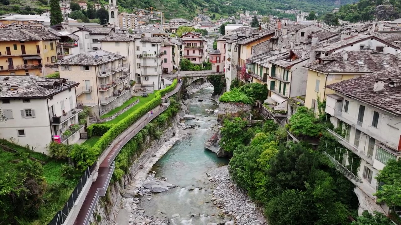 Vista aerea nuvolosa di Chiavenna, che evidenzia il ponte e il paesaggio più vasto.