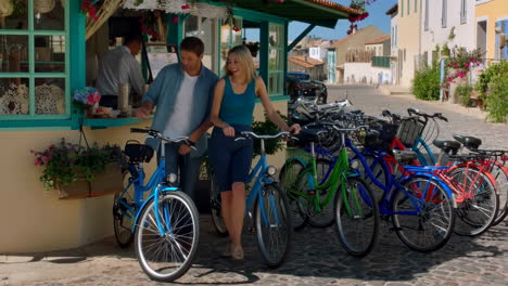 a couple interacting at a bicycle rental shop in a european town