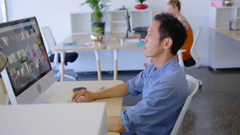 Young-male-executive-working-on-desktop-pc-at-desk-4k