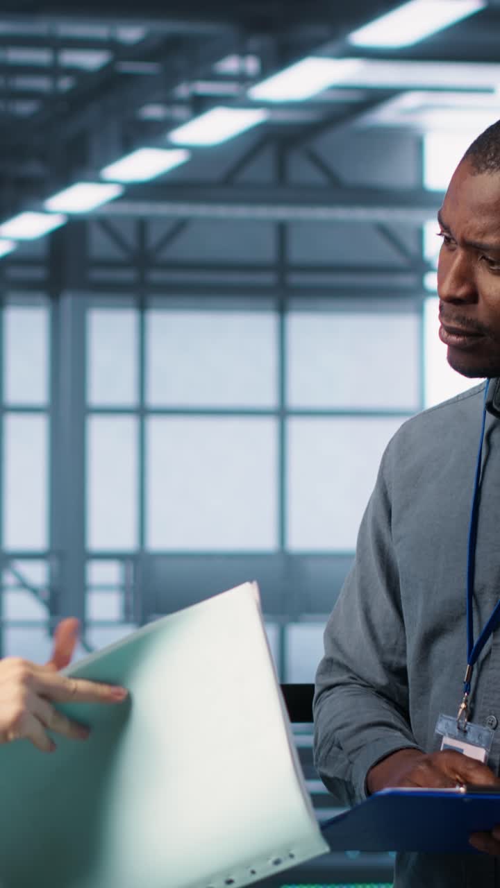 Vertical video Cheerful admins meeting in data center to review reports, doing handshake