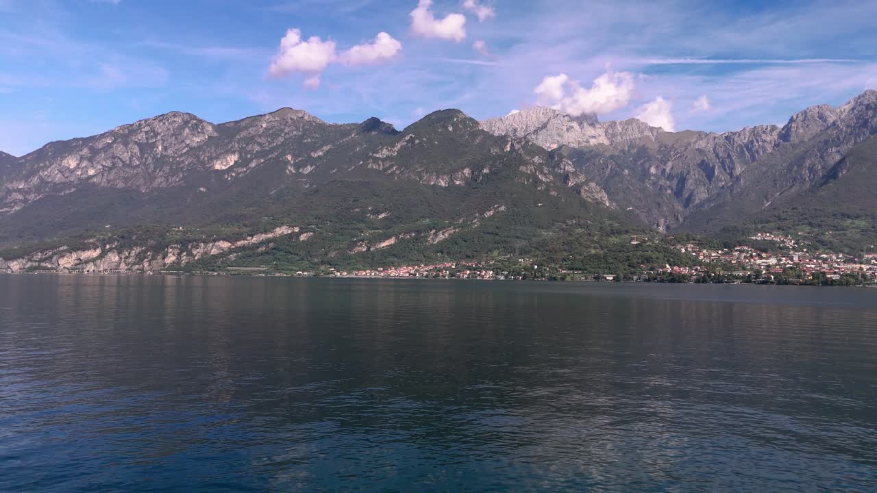 People kayaking on Lake Como, Mandello del Lario and mountains in background