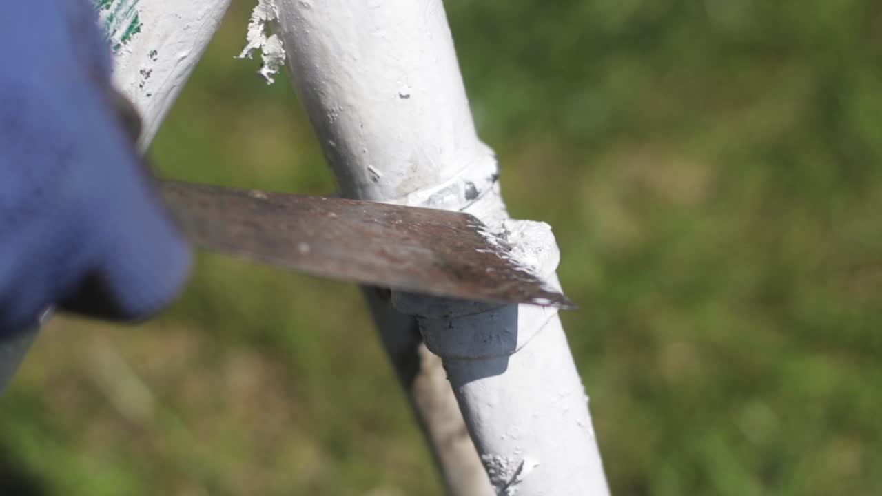 Scrubbing the old white paint of a rusty bicycle. Bike restoration.
